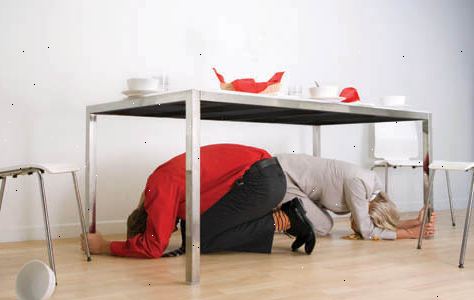Hoe tijdens een aardbeving reageren. Zoek dekking door het krijgen van onder een stevige tafel of ander meubelstuk, en vasthouden totdat het schudden stopt.