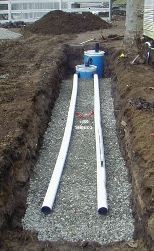 Hoe maak je een kleine septische systeem te construeren. Graaf een greppel 4 meter breed, 26 meter lang en 3 meter diep.
